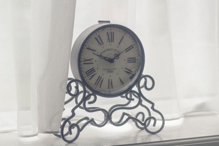 Metal clock in window_Tomasz Bazylinski_Stocksnap